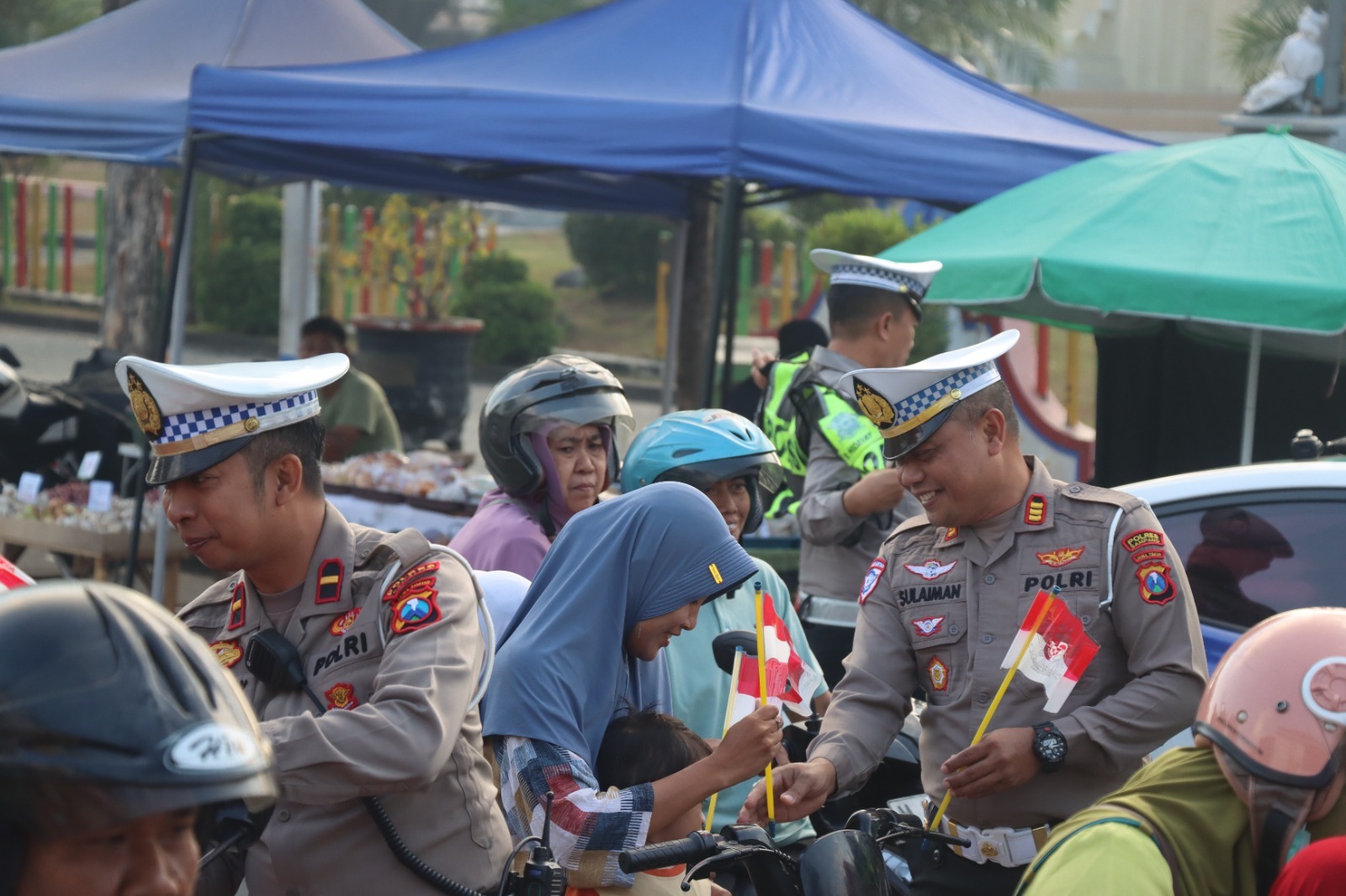 Tumbuhkan Nasionalisme dan Tertib Berkendara, Satlantas Polres Sampang Bagikan Bendera Merah Putih di Simpang Empat Monumen